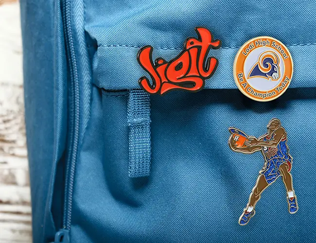 Backpack with custom enamel pins decorating it.